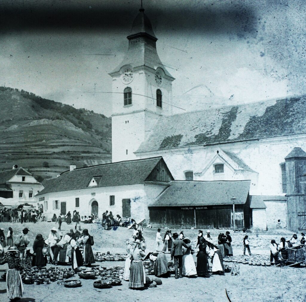Az unitárius templom és a tér 1907-ben, népviseletes alakokkal, a templom melletti kis épületen tűzoltószertár felirat